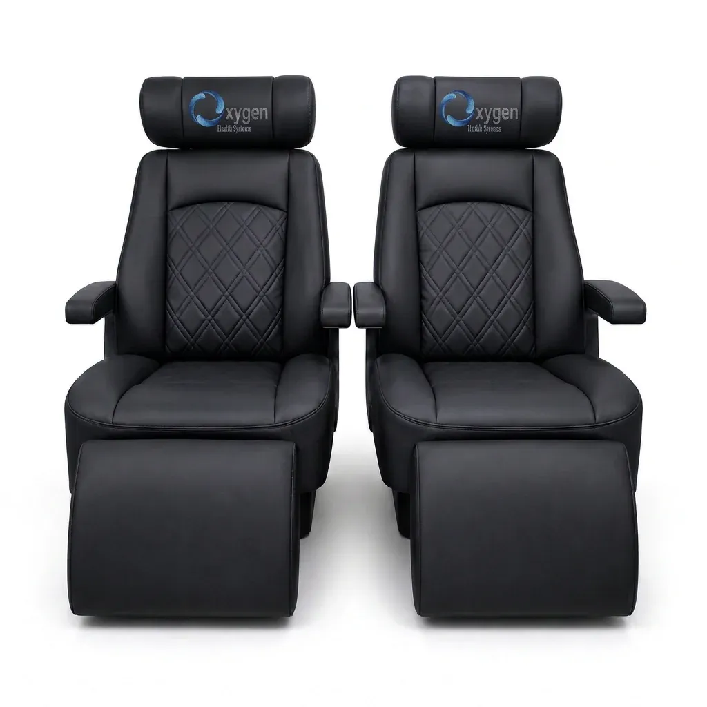 Two black quilted leather captain's chairs with extended footrests, diamond-stitched center panels, padded armrests, and Oxygen Health Systems embroidered headrests