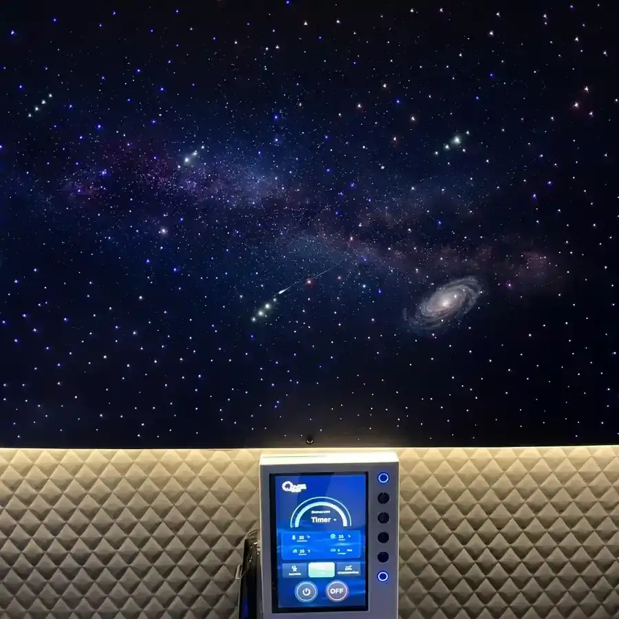 Starlight simulated ceiling inside the hyperbaric chamber — a night-sky panel with stars, the Milky Way, and a galaxy above quilted interior padding and a touchscreen control panel